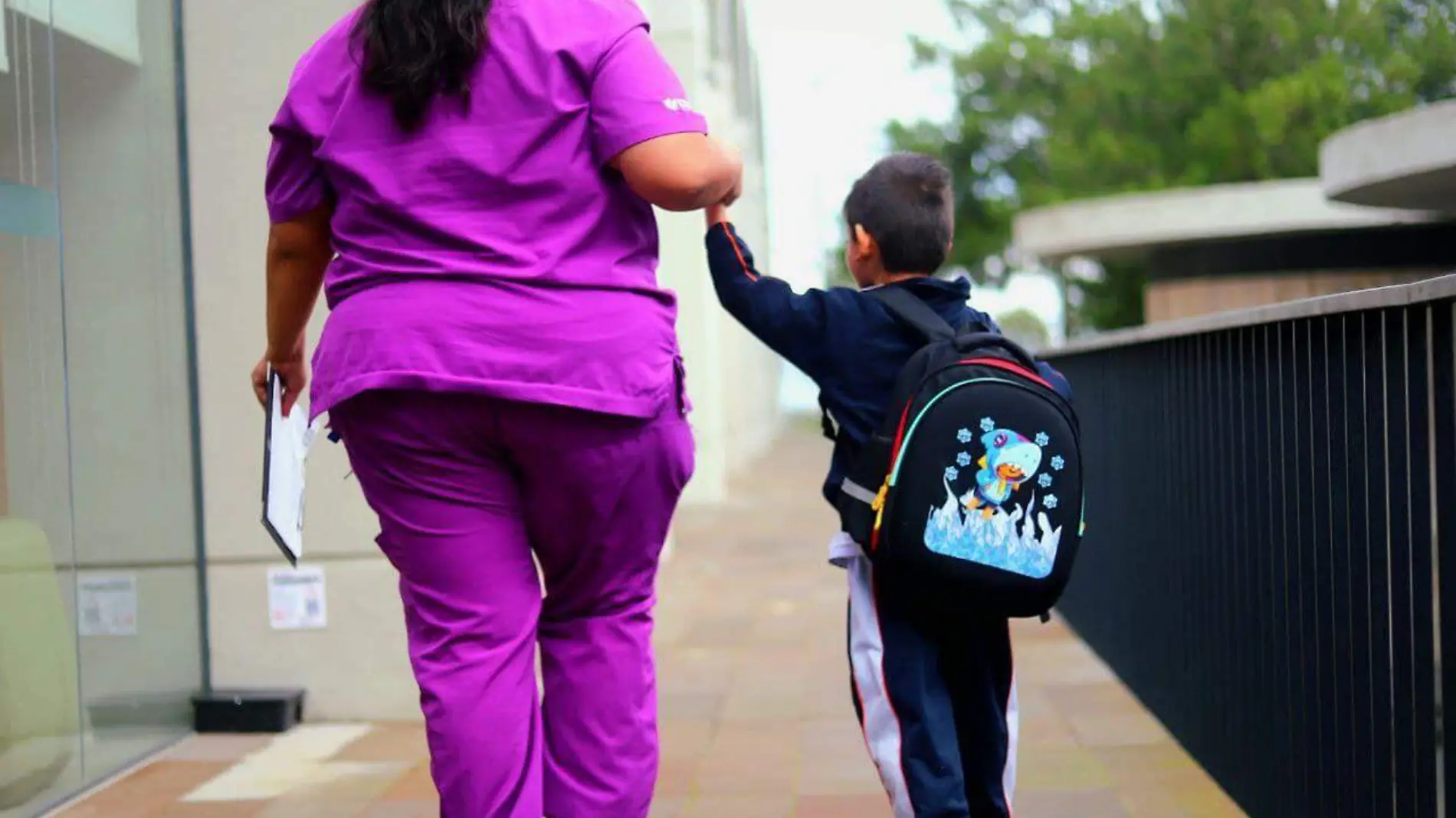 Trabajora del Centro de Autismo Morelia junto a un niño